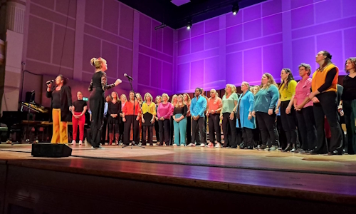 Koor met soliste op het podium in de Grote zaal van de Vereeeniging in Nijmegen